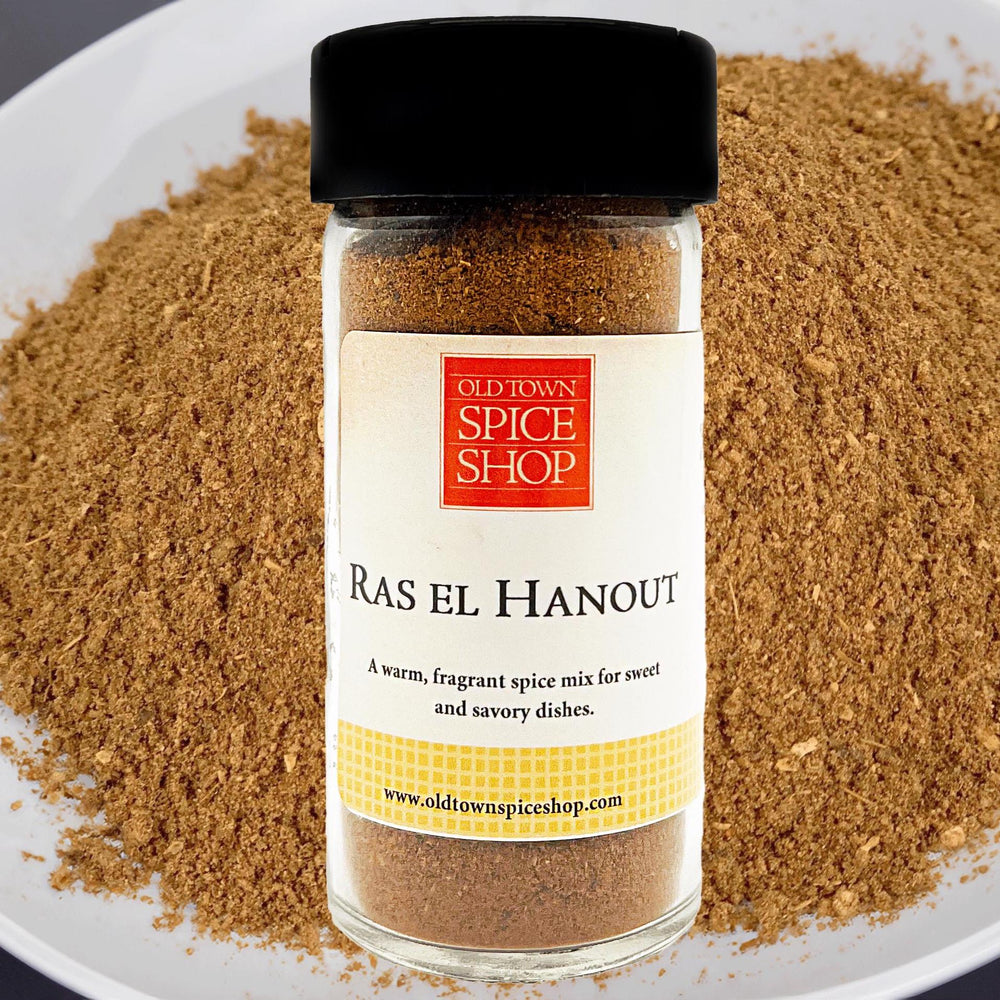 Jar of Old Town Spice Shop Ras El Hanout spice mix on a plate with ground spice around it.