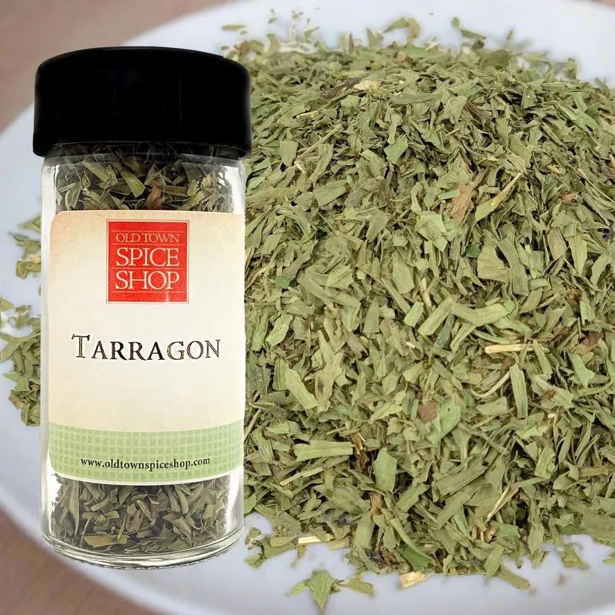 Jar of tarragon from Old Town Spice Shop with tarragon leaves on a white surface