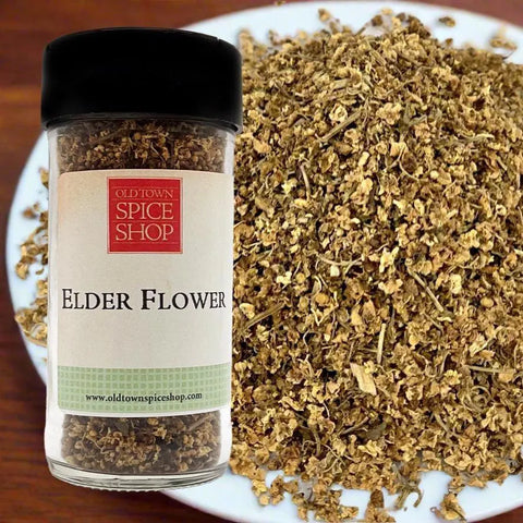 Jar of Old Town Spice Shop Elder Flower next to a plate of dried elder flowers.