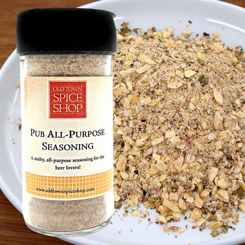 Bottle of Old Town Spice Shop Pub All-Purpose Seasoning next to a plate of mixed herbs and spices.