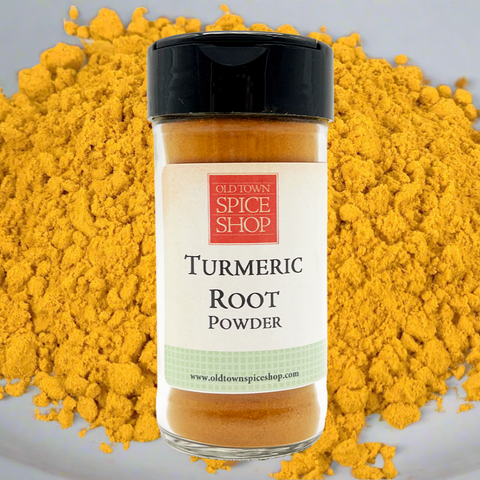 Turmeric root powder jar with a pile of yellow powder on a gray background