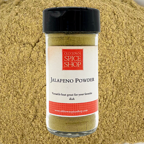 Jalapeno powder jar from Old Town Spice Shop on a bed of ground pepper.