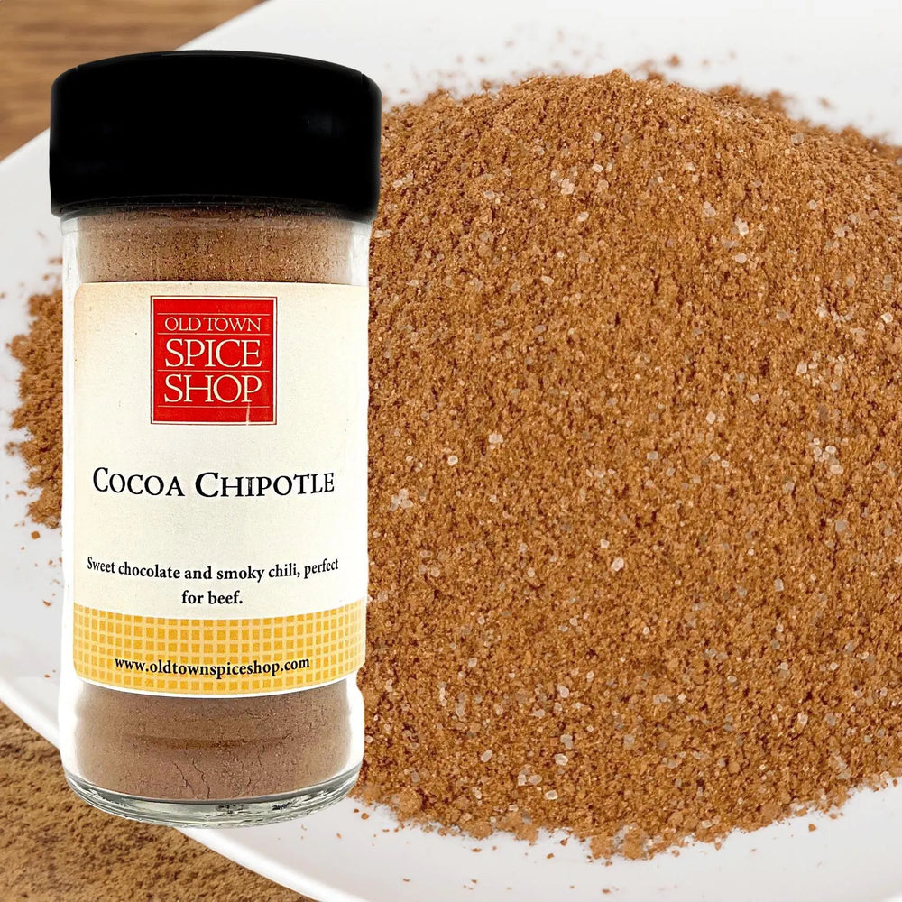 Jar of Old Town Spice Shop Cocoa Chipotle spice with a close-up of the spice on a white surface.