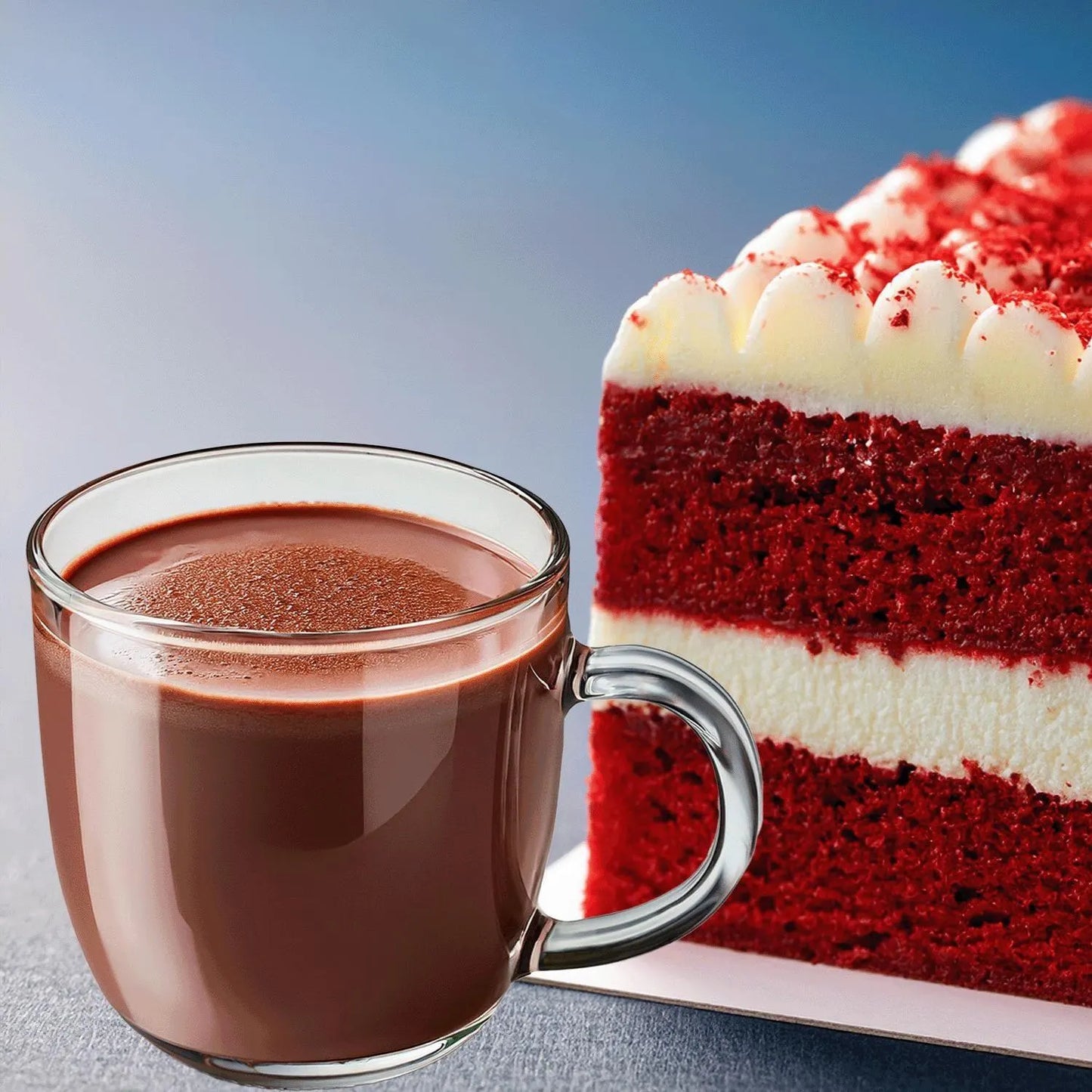 Glass mug of hot chocolate next to a slice of red velvet cake on a light blue background