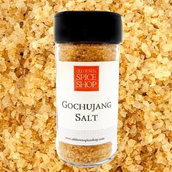 
                      
                        Bottle of Old Town Spice Shop Gochujang Salt with a black lid on a textured salt background.
                      
                    