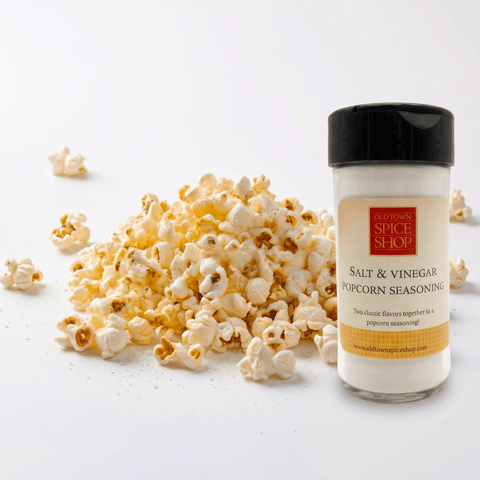 Popcorn and a bottle of Old Spex Spice Shop Salt & Vinegar Popcorn Seasoning on a white background