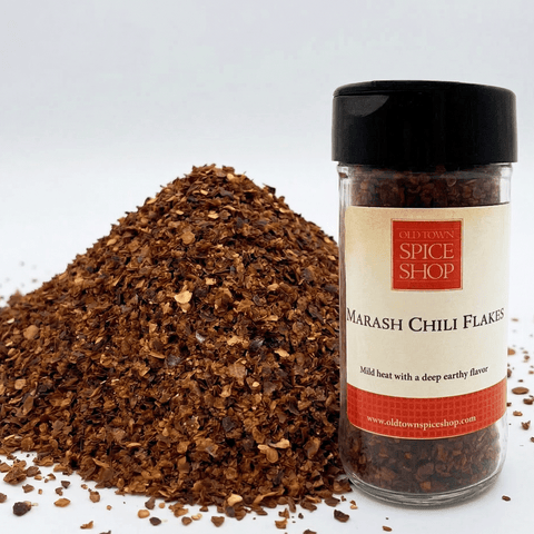 Jar of Old Town Spice Shop Marash Chilli Flakes with a pile of chili flakes on a white background
