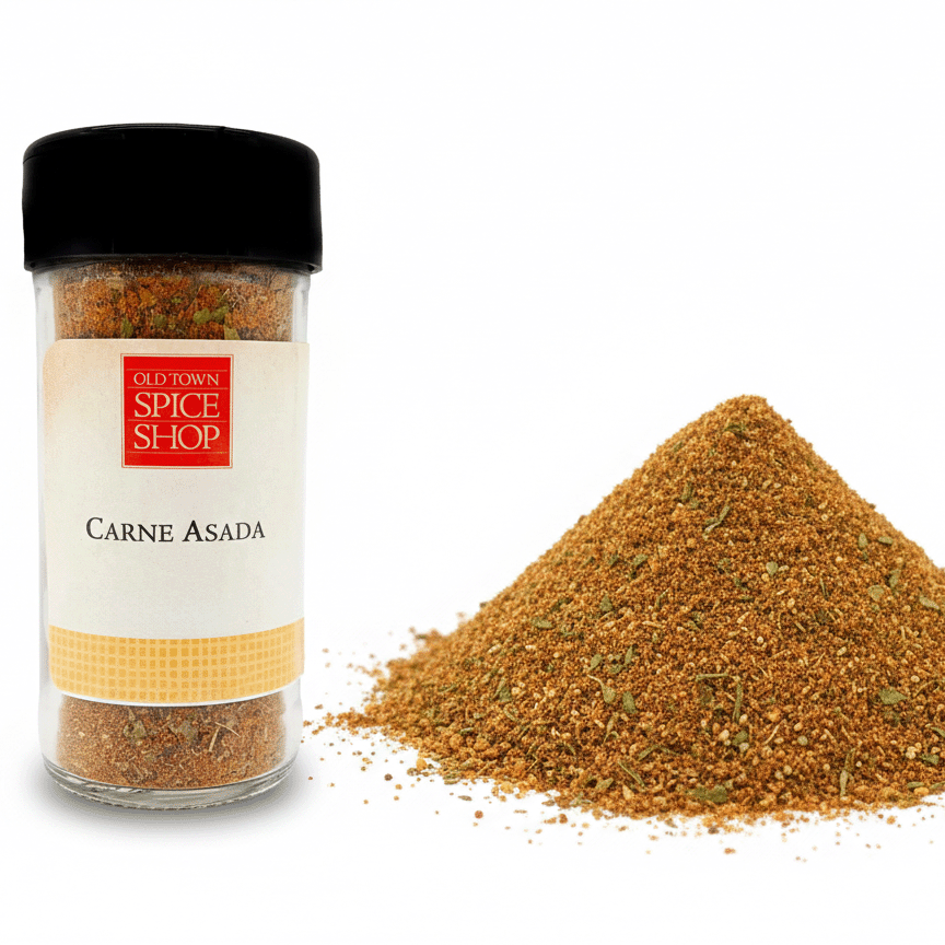 Spice jar labeled 'Carne Asada' from Old Town Spice Shop with spilled spice on a white background