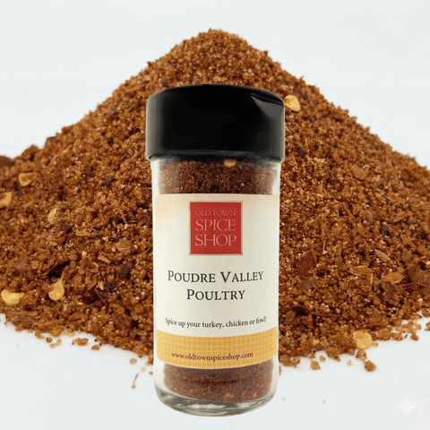 Spice jar labeled 'Poudre Valley Poultry' from Old Town Spice Shop with a pile of brown spices in the background.