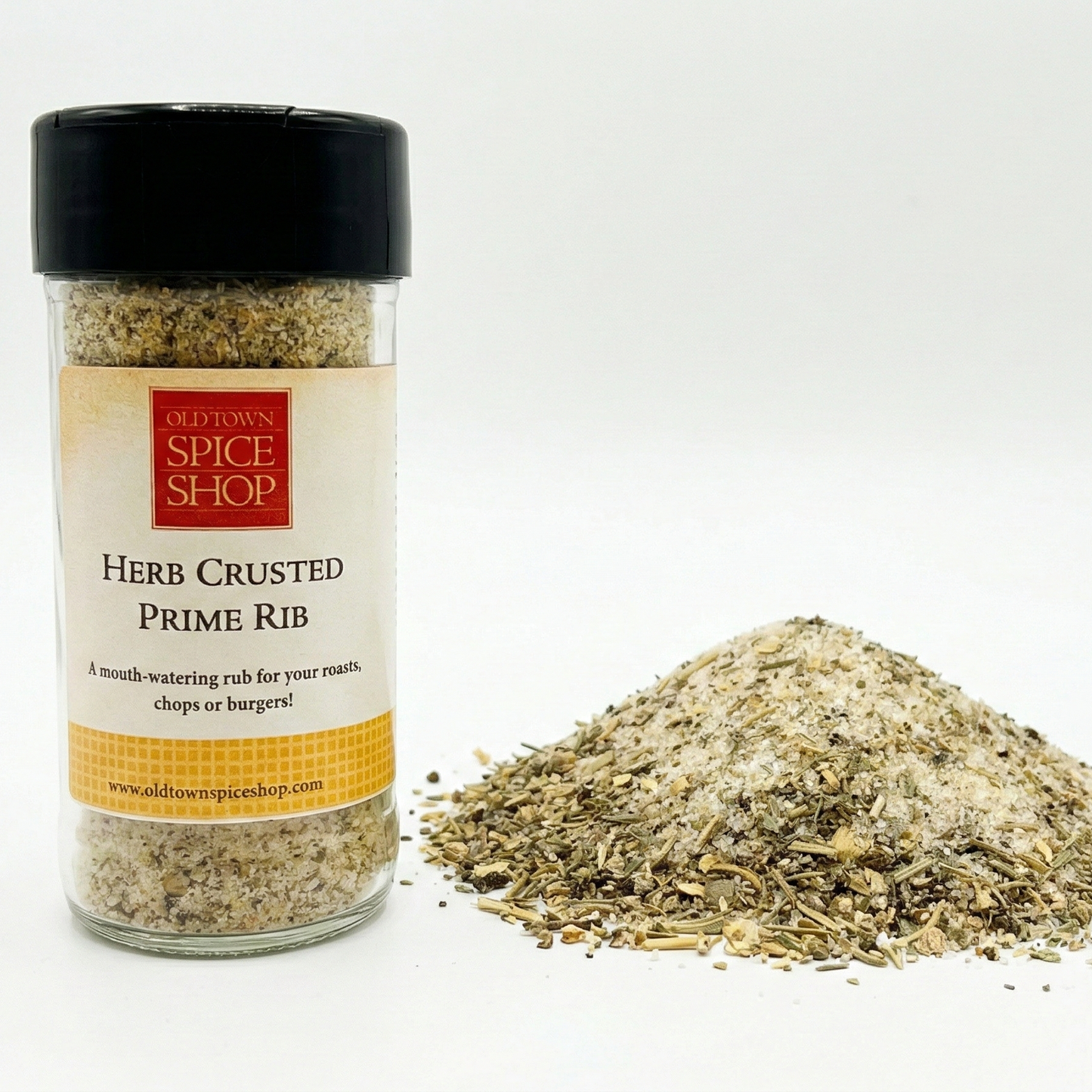 Spice jar labeled 'Herb Crusted Prime Rib' from Old Town Spice Shop with spilled spice mix on a white background.