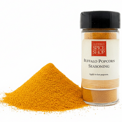 Spice jar labeled 'Buffalo Popcorn Seasoning' from Old Spice Shop with yellow powder on a white background