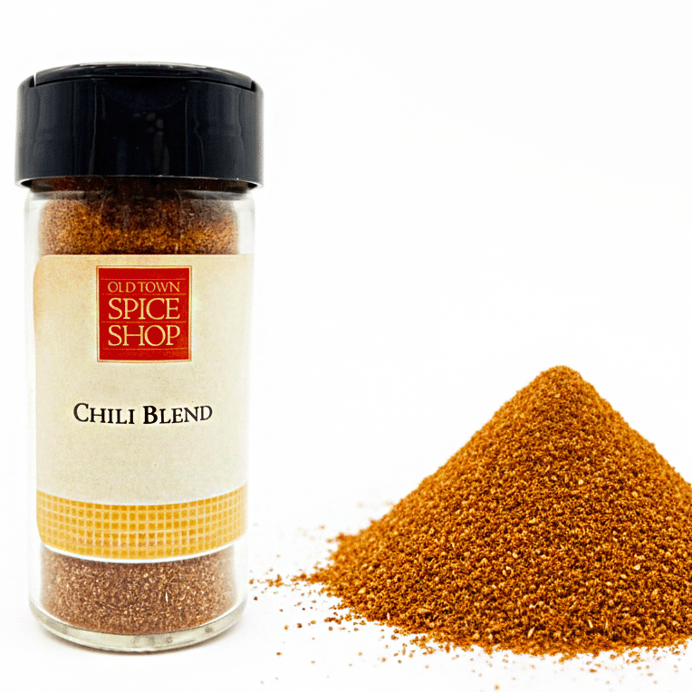 Jar of Old Town Spice Shop Chili Blend with spilled spice on a white background
