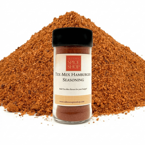 Jar of Tex-Mex Hamburger Seasoning from Old Town Spice Shop with a pile of seasoning in the background.