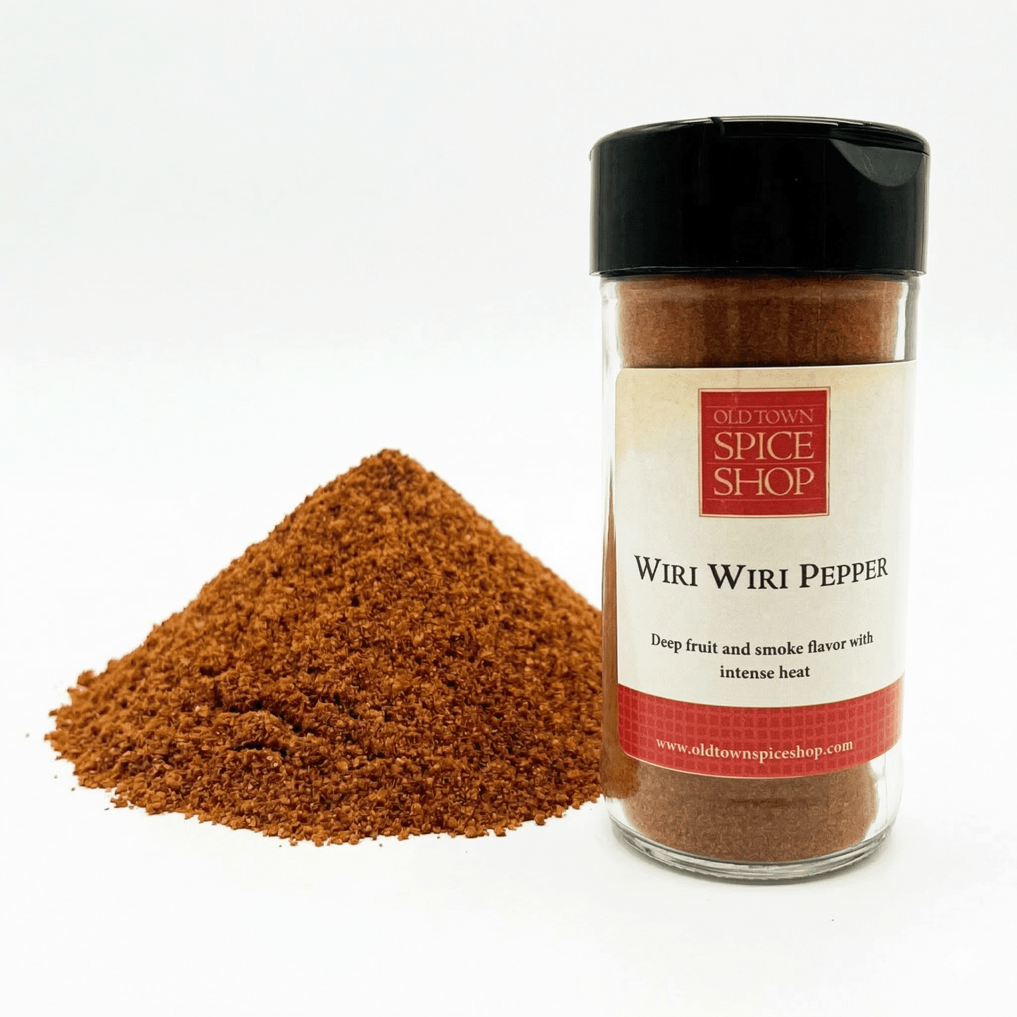 Jar of Old Town Spice Shop Wiiri Wiiri Pepper with a pile of ground pepper on a white background
