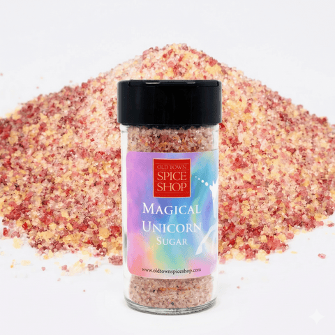 Jar of 'Magical Unicorn Sugar' from Old Town Spice Shop with colorful sugar in the background.