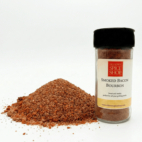 Spice jar labeled 'Smoked Bacon Bourbon' from Old Town Spice Shop with spilled spice on a white background
