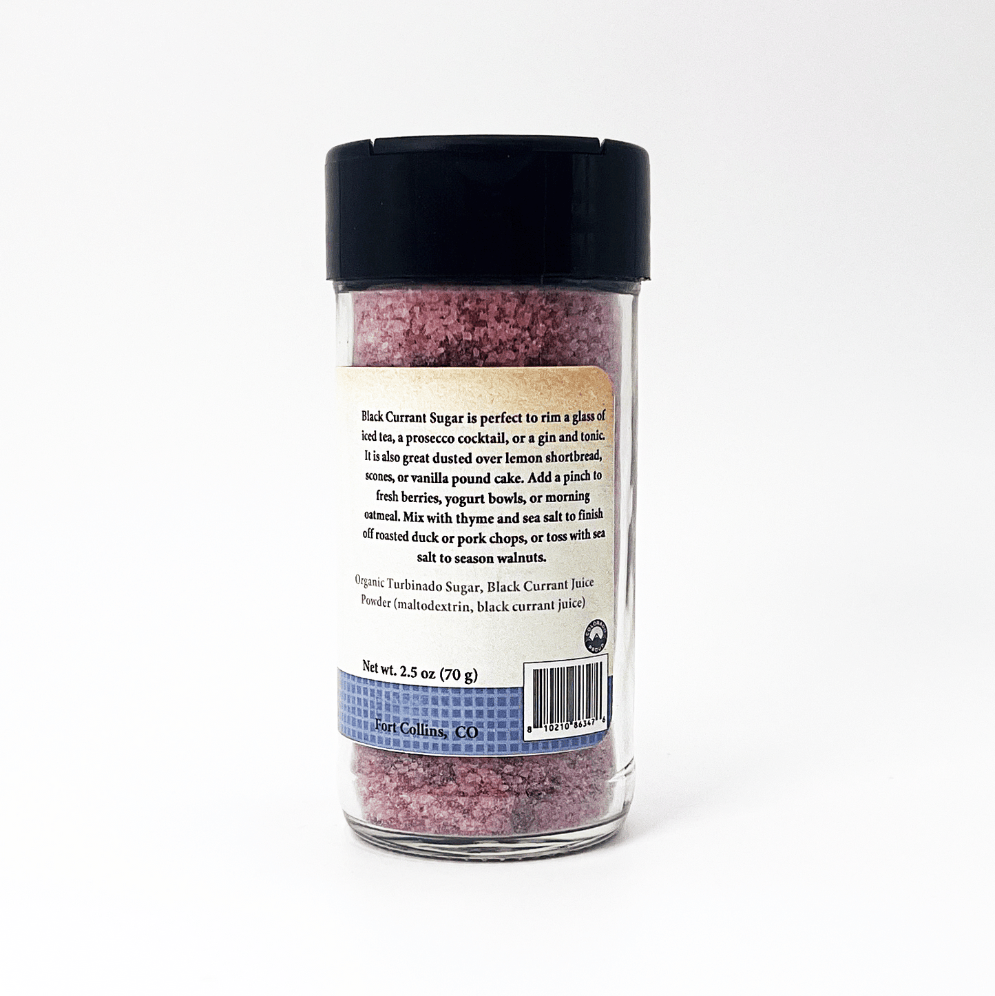 A clear plastic shaker bottle of black current sugar with a black lid, showing the back of the label with product details, on a white background.
