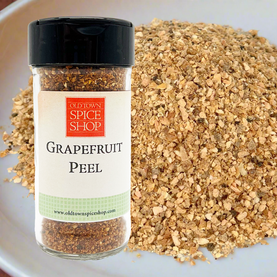 Grapefruit peel spice jar from Old Town Spice Shop on a white plate with ground grapefruit peel.