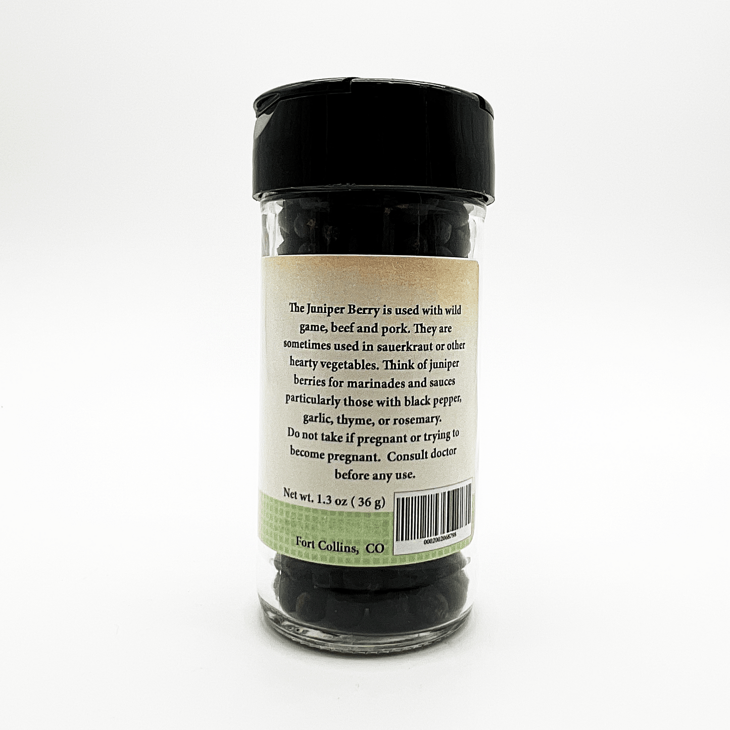 A clear plastic bottle of Fort Collins, CO juniper berries with a black screw cap, showing the back label with product description and barcode on a white background.