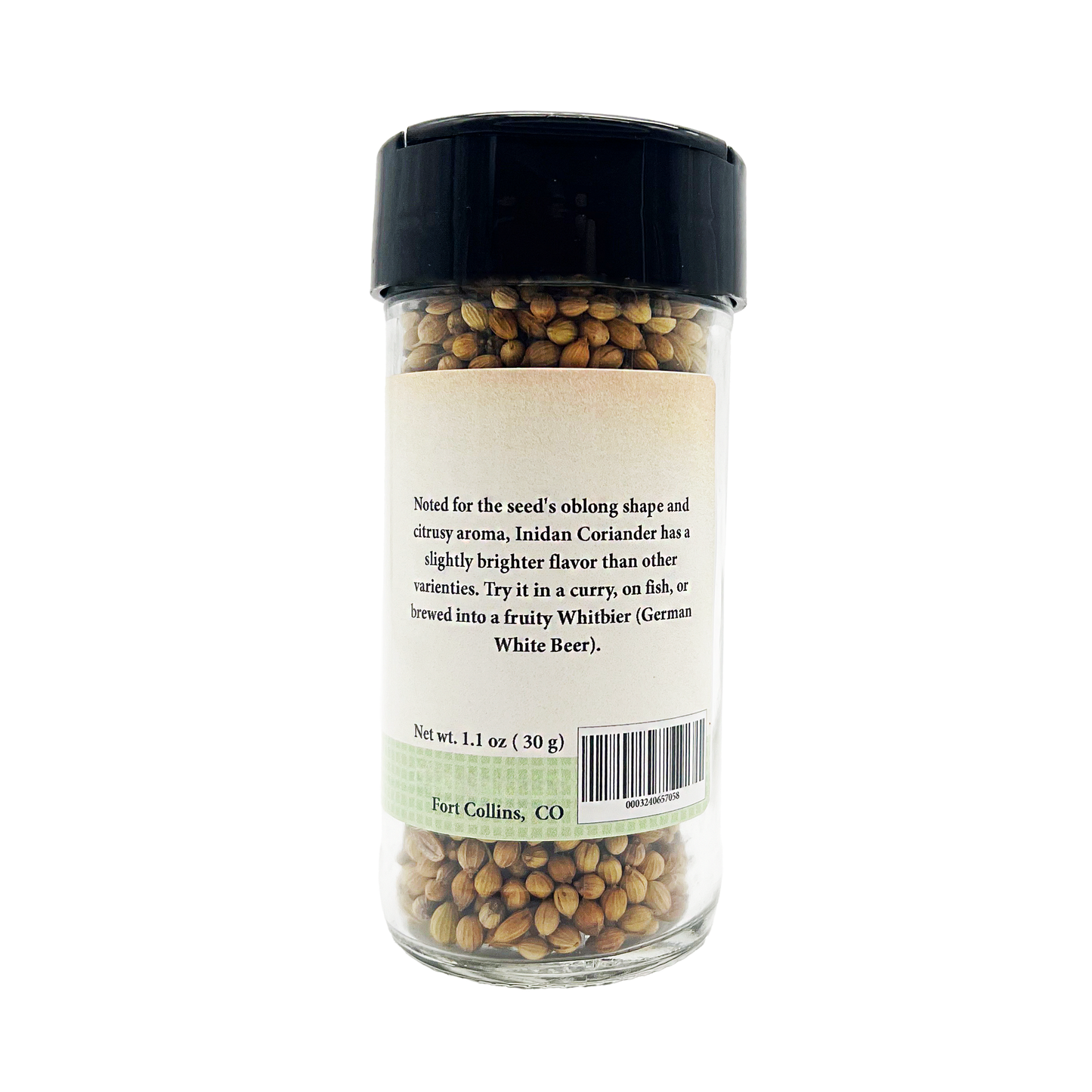 Glass jar of coriander seeds with a label on a white background