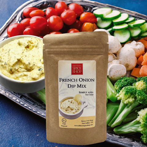 Bowl of creamy French Onion dip with potato chips and vegetables