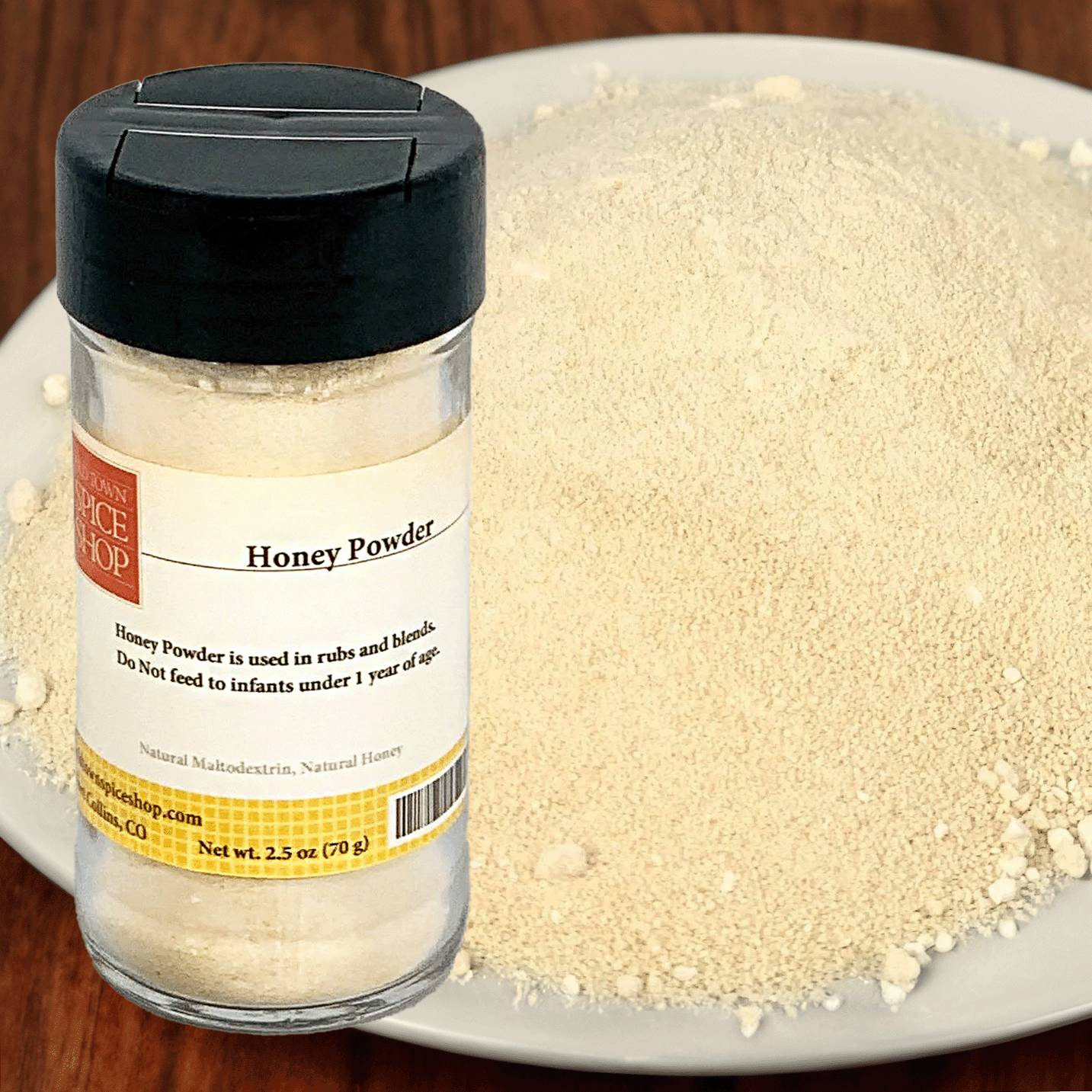 Jar of honey powder with a label on a plate of honey powder