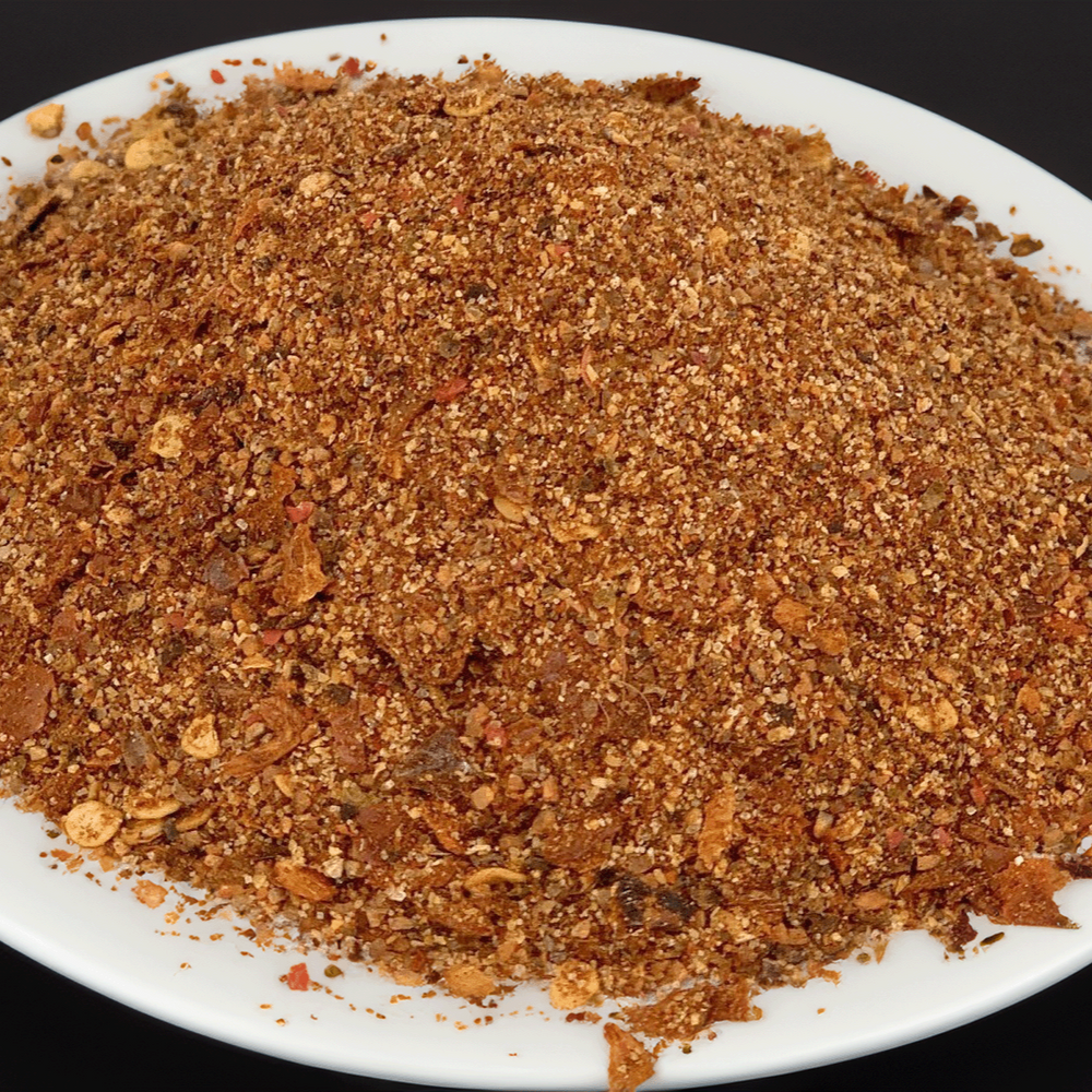 
                      
                        Brown spice mix on a white plate with a black background
                      
                    